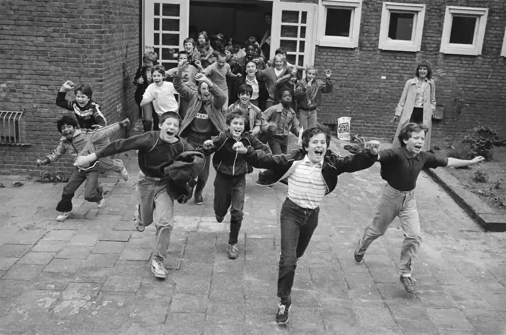 Kinderen die naar buiten rennen als de school is afgelopen en vakantie begint